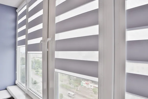 Fenster mit halb heruntergelassenem Jalousie.